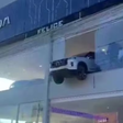 Carro fica pendurado no segundo andar de concessionária após acidente em Porto Alegre