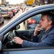 Ele acendeu um cigarro para encarar o engarrafamento e terminou o dia com menos 4 pontos na carteira: agente flagra condutor sem as mãos no volante e aplica multa média
