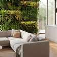 Parede verde transforma sala integrada à cozinha em um ambiente biofílico moderno