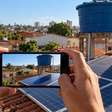 Morador instala uma caixa-d'água elevada para enfrentar faltas no abastecimento e o vizinho afirma que a nova estrutura passou a sombrear seus painéis solares durante a manhã