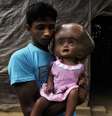 Abdul Rahman posa com sua filha, Roona Begum, na casa família em Jirania, em 12 de abril  Foto: AFP