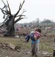 <p>Mulher carrega criança em meio aos destroços da passagem do tornado em Moore, no subúrbio da Cidade de Oklahoma</p>  Foto: AP