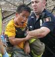 Menino é retirado dos escombros de escola por policial   Foto: Sue Ogrocki / AP
