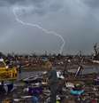 Sob mau tempo, moradores Moore, Oklahoma, limpam os destroços depois da passagem de um tornado, no dia 20  Foto: AFP