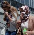 Mulheres tentam se proteger do gás durante protesto em Ancara  Foto: AP