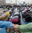 Manifestantes dão as mãos para proteger outros que rezam na Praça Taksim, em Istambul, nesta sexta-feira  Foto: AP