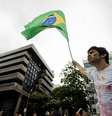 <p>Com bandeira do Brasil, manifestante faz coro a protesto na frente da casa de Cabral</p>  Foto: Mauro Pimentel / Terra