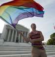 Ativista Vin Testa agita bandeira do movimento gay na frente do prédio da Suprema Corte americana, em Washington  Foto: AP