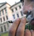 <p>Homem fuma maconha do lado de fora do Congresso uruguaio, onde o projeto foi votado na última quarta-feira</p>  Foto: AP