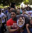Manifestantes carregam homem ferido durante os protestos em Gizé  Foto: AFP