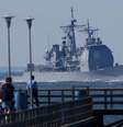 <p>Turistas observam o navio de guerra cruzador de mísseis USS Mahan partindo para o oceano Atlântico, perto de Virginia Beach, nos Estados Unidos, em setembro de 2003</p>  Foto: Chip East cme / Reuters