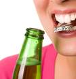 Abrir garrafas com os dentes Esse é um hábito prejudicial, que pode levar à fratura dos dentes. O resultado pode ser uma simples restauração, mas também a necessidade de um implante, dependendo do nível do estrago causado no dente.  Foto: Shutterstock