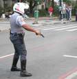 Policial atira para o chão após ser cercado por grupo de manifestantes, em São Paulo  Foto: Rocha Lobo / Futura Press