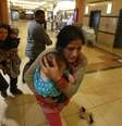 <p>Mulheres carregando crianças são retiradas de shopping center em Nairóbi</p>  Foto: Goran Tomasevi / Reuters