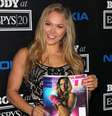 <p>Ronda Rousey mostra revista esportiva que exalta seu corpo</p>  Foto: Getty Images 