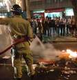<p>Bombeiro apaga um dos vários focos de incêndio promovido pelos manifestantes durante protesto na terça-feira</p>  Foto: André Naddeo / Terra