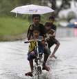 Crianças circulam pelas ruas inundadas de Taguig   Foto: EFE