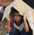 Criança aguarda um voo de evacuação no aeroporto de Tacloban  Foto: AP