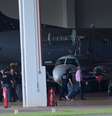 <p>Avi&atilde;o da PF com condenados do mensal&atilde;o chega ao aeroporto de Bras&iacute;lia. Na foto, Jos&eacute; Genoino (de camisa rosa) &eacute; conduzido por policiais federais</p>  Foto: Pedro França / Futura Press
