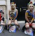 <p>Ativistas do Femen urinam sobre fotos do presidente ucraniano em Paris, durante ato em apoio aos protestos pró-União Europeia na Ucrânia</p>  Foto: AFP