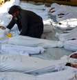 Homem segura o corpo de criança morta em ataque de gás em 21 de agosto  Foto: Reuters
