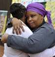 Duas mulheres se consolam em frente à casa em que Mandela morou em Soweto  Foto: Reuters