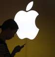 Uma mulher olha para a tela de seu celular na frente de um logotipo da Apple, fora da loja da Apple no centro de Xangai. A Samsung Electronics perdeu nesta terça-feira sua ação para banir as vendas das versões antigas do iPhone e iPad da Apple na Coreia do Sul, depois que um tribunal descartou um processo alegando que a empresa norte-americana infringiu três patentes de celular da Samsung. 10/09/2013  Foto: Aly Song / Reuters