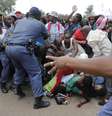 Polícia tenta conter a multidão que se empurra para chegar ao local onde o corpo de Mandela é velado  Foto: AP