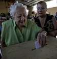 Mulher deposita voto em urna de seção eleitoral em Santiago  Foto: Reuters