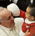 Criança brinca com o chapéu do Papa durante a audiência de sábado no Vaticano  Foto: AP