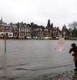 Mulher tenta se proteger do vento e da chuva em calçada alagada pelo rio Ouse em York, na Inglaterra  Foto: AP