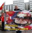 <p>F&atilde; franc&ecirc;s da Ferrari segura bandeira com a imagem de Schumacher em frente ao hospital</p>  Foto: Charles Platiau / Reuters