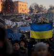 Homem exibe a bandeira ucraniana na Praça Independência, em Kiev, epicentro da mobilização opositora  Foto: AP