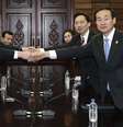 Representantes das Coreias se cumprimentam durante reunião  Foto: AP