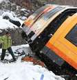 Trem  se chocou contra uma rocha que caiu na via e um dos vagões do trem virou  Foto: AFP