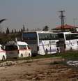 Famílias sírias deixam, em ônibus, a cidade de Homs, que virou um campo de batalha  Foto: AP