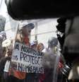 Manifestantes seguram placas e cartazes durante protesto contra o governo, em Caracas  Foto: Reuters