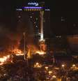 Manifestantes contra o governo se juntam perto do fogo em acampamento montado durante os confrontos com a polícia, em Kiev  Foto: Reuters