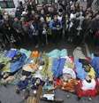 Pessoas rezam próximas aos corpos de manifestantes contrários ao governo mortos durante os confrontos em Kiev  Foto: Reuters