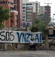 Mulher venezuelana sentada em rua bloqueada em San Cristobal, capital do estado de Tachira, em 23 fevereiro  Foto: AFP