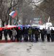 <p>Segurando uma bandeira russa, manifestantes marcham em frente ao prédio do governo, na Crimeia. De acordo com o Ministro do Interior ucraniano, a polícia está em alerta máximo depois que dezenas de manifestantes invadiram o edifício do Parlamento de Simferopol</p>  Foto: AP