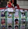 <p>Mulher segura vela e&nbsp;um cartaz que mostra fotos de crian&ccedil;as desaparecidas, na prov&iacute;ncia central chinesa de Hubei, em 24 de janeiro 2010</p>  Foto: AP