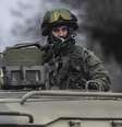 Homem uniformizado olha de cima de um veículo militar enquanto tropas tomam o controle dos escritórios da Guarda Costeira em Balaclava, periferia de Sevastopol, Ucrânia, neste sábado  Foto: AP