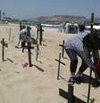 <p>Cruzes com nomes de v&iacute;timas da viol&ecirc;ncia na Venezuela s&atilde;o fixadas nas areias da praia em Puerto La Cruz</p>  Foto: Reuters