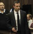 Observado por June Steenkamp (à dir.), mãe de Reeva, Oscar Pistorius chega ao tribunal de Pretória para o início do julgamento pela morte da namorada  Foto: AP