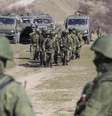 <p>Tropas tidas como forças militares russas andam pelo lado de fora de uma base militare ucraniana, na vila de Perevalnoye, próxima a Simferopol</p>  Foto: Baz Ratner / Reuters
