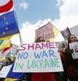 Pessoas acompanham, do lado de fora, uma reunião de emergência dos ministros do exterior da União Europeia, em Bruxelas, protestando contra a presença das tropas russas na Ucrânia, em 3 de março  Foto: Reuters