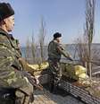 Soldados de fronteira vigiam a entrada da base naval de Novoozernity. Houve denúncias de que a Rússia teria bloqueado canal que separa da Crimeia   Foto: EFE