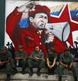 Soldados venezuelanos sentam em frente a um mural com a imagem de Hugo Chávez, em 27 de fevereiro  Foto: Reuters