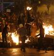 <p>Manifestantes contra o governo se protegem das forças policias atrás e barricadas durante protesto em Ankara, na noite de 12 de março</p>  Foto: Reuters